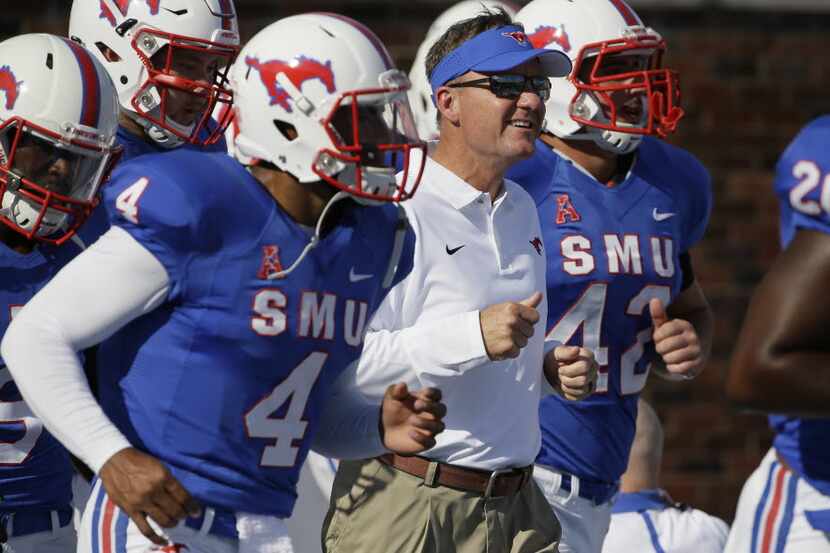 SMU head coach Chad Morris, center, takes field with his team for warm ups before an NCAA...