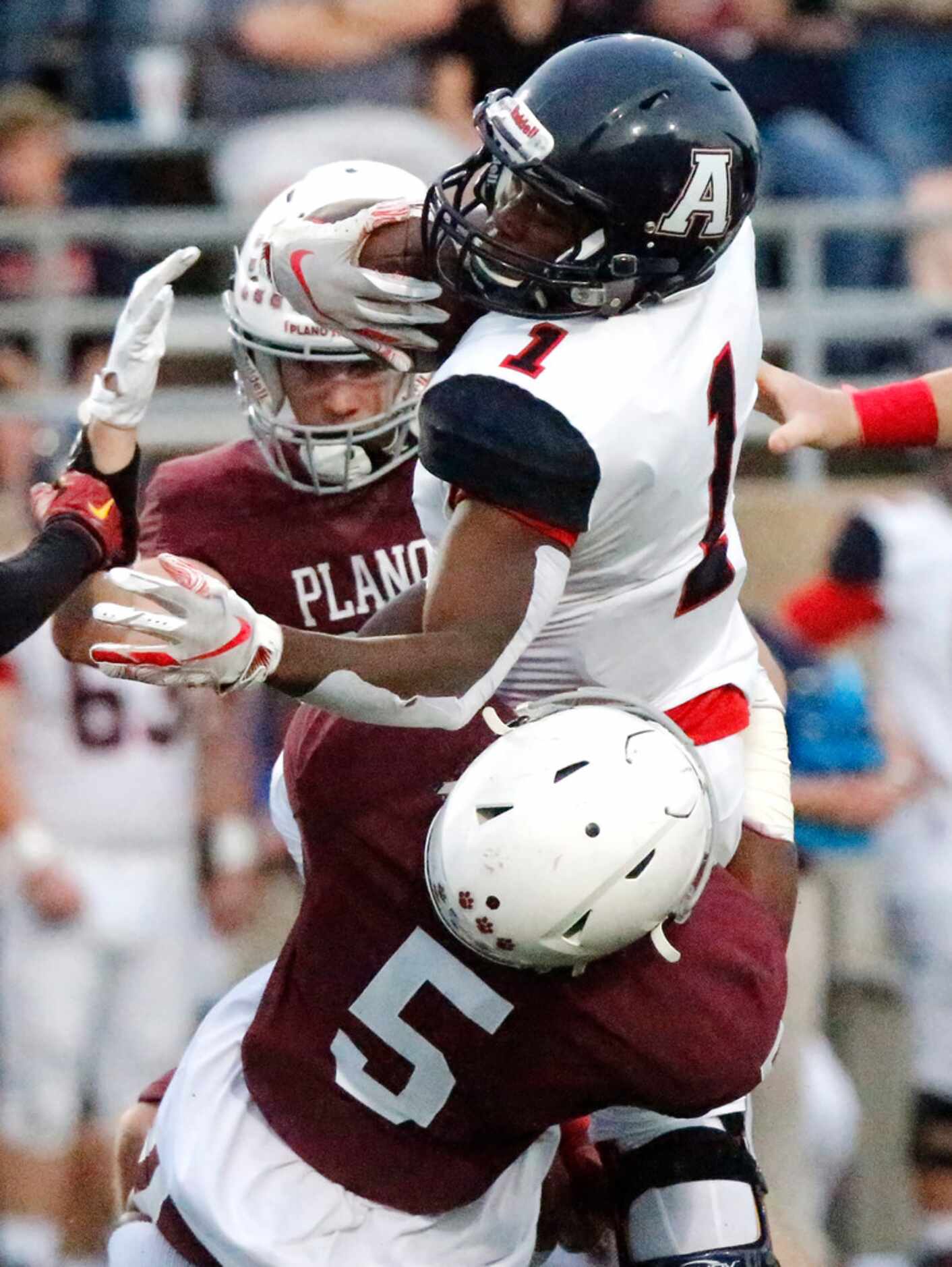 Allen High School running back Celdon Manning (1) is tackled by Plano High School linebacker...
