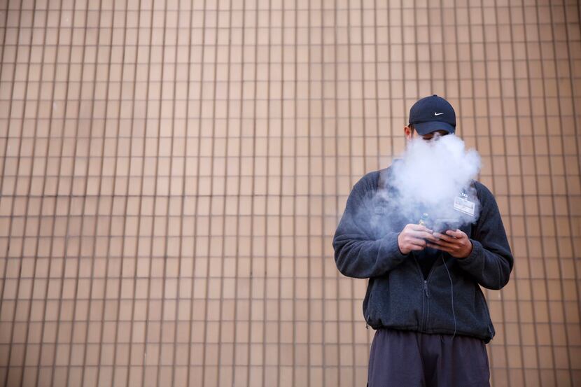 Tommy Nguyen, 27, vapes outside El Centro College in downtown Dallas.