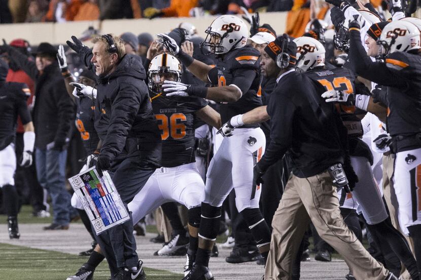 Oklahoma State Cowboys defensive coach Glenn Spencer celebrates after a fumble recovery...