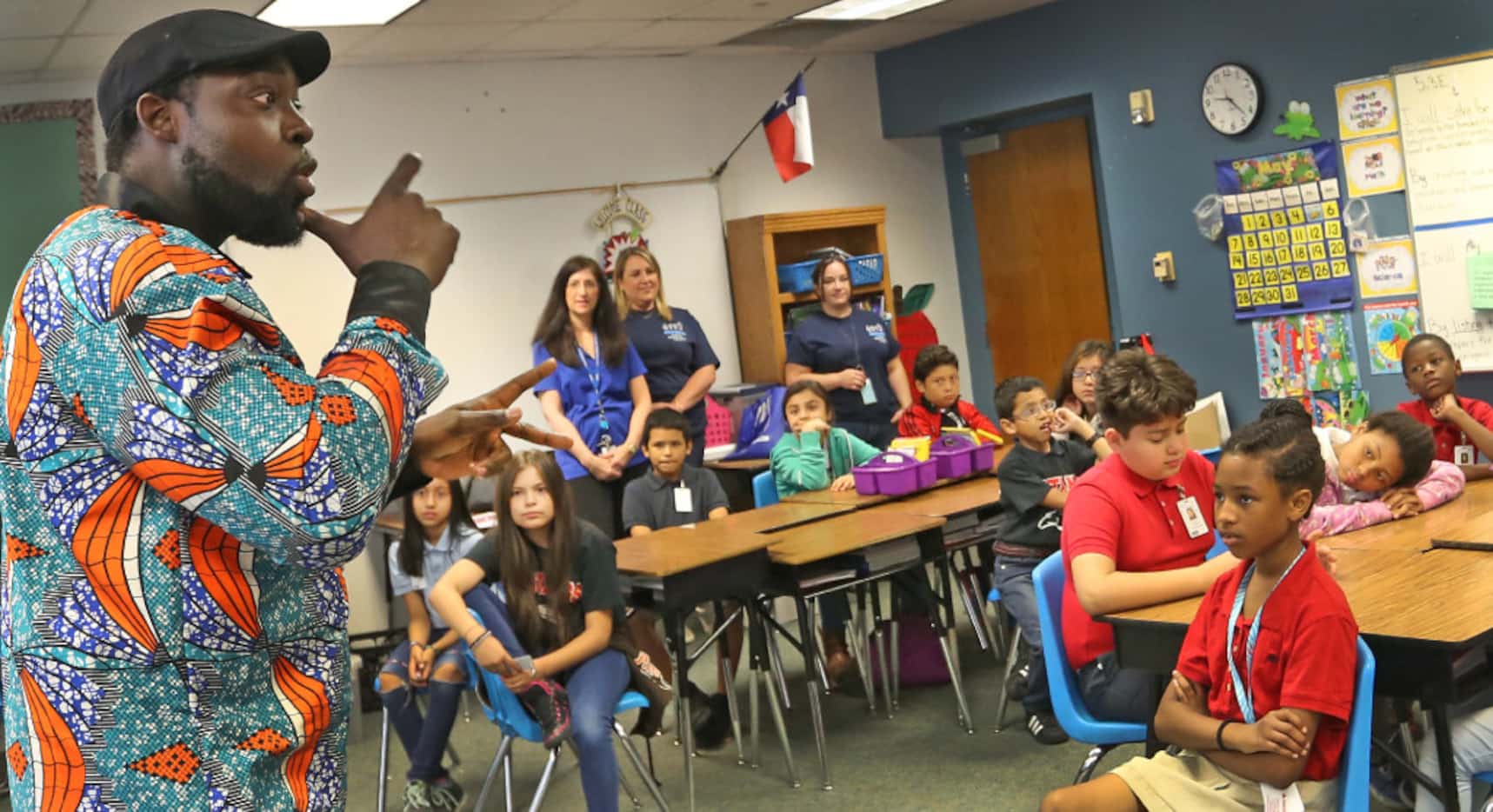 Antoine Dinka, who as a youngster attended Britain Elementary, signs to students as he tells...