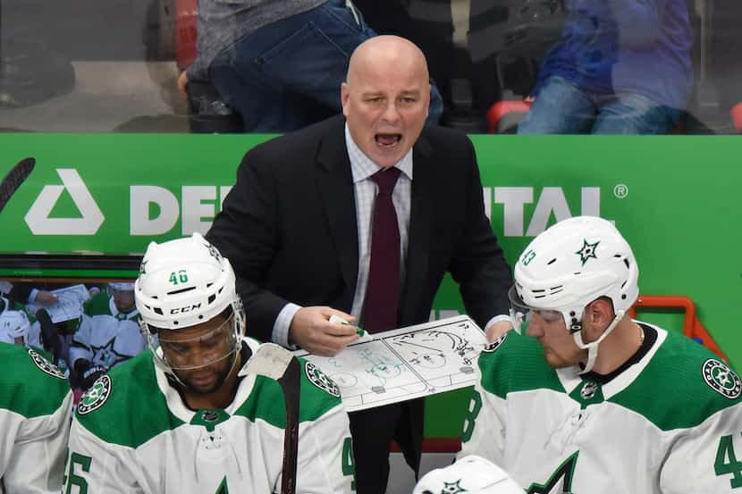 Dallas Stars head coach Jim Montgomery, top, gives instructions to his team during a break...