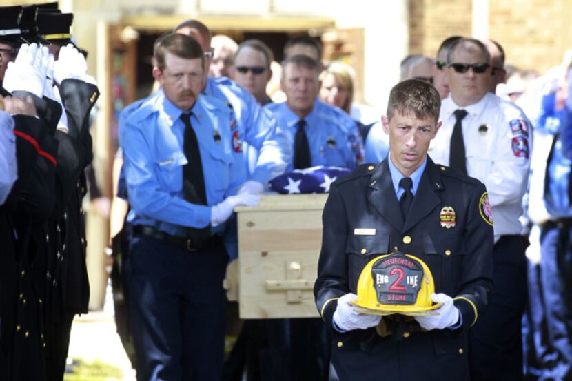 Brownwood Fire Department Lt. G. Neson carries the helmet of Lt. Shannon Stone ahead of...
