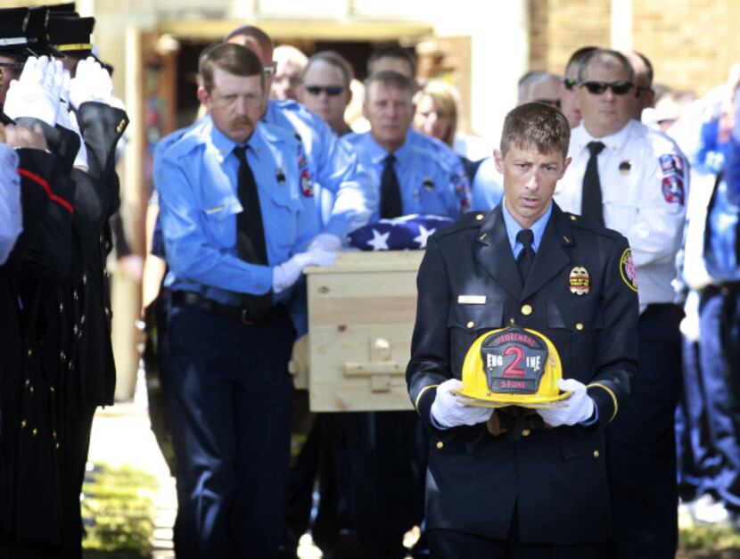 Brownwood Fire Department Lt. G. Neson carries the helmet of Lt. Shannon Stone ahead of...