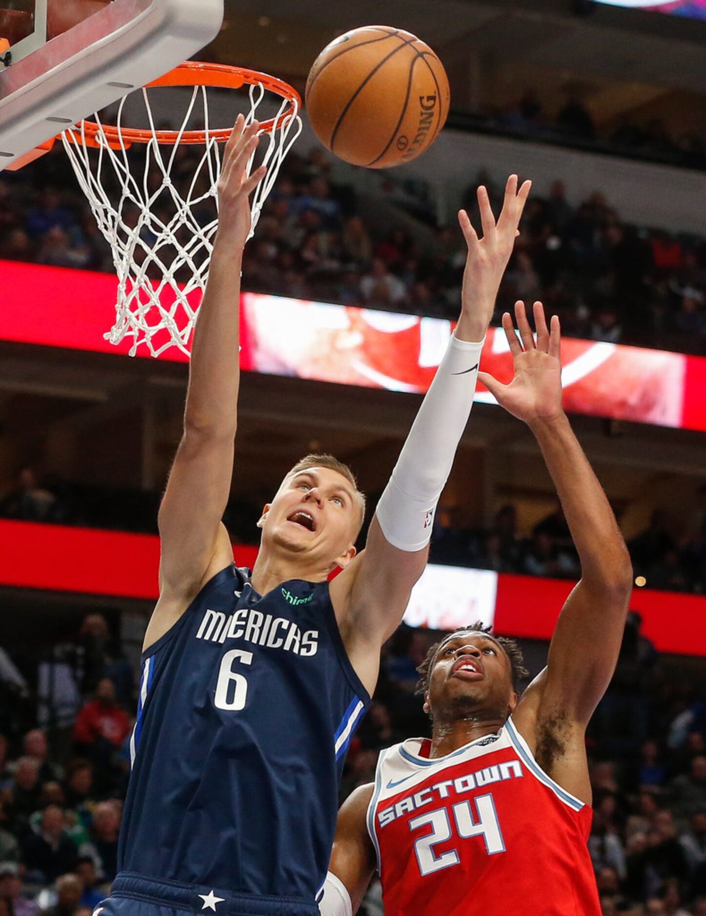 Dallas Mavericks forward Kristaps Porzingis (6) goes up for a rebound over Sacramento Kings...