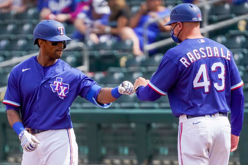 Texas Rangers designated hitter Khris Davis celebrates with  field coordinator/first base...