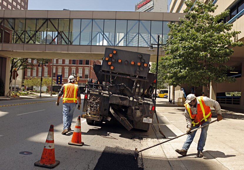 Roger Scruggs, a crew leader with the City of Dallas Street Services, and worker Natividad...