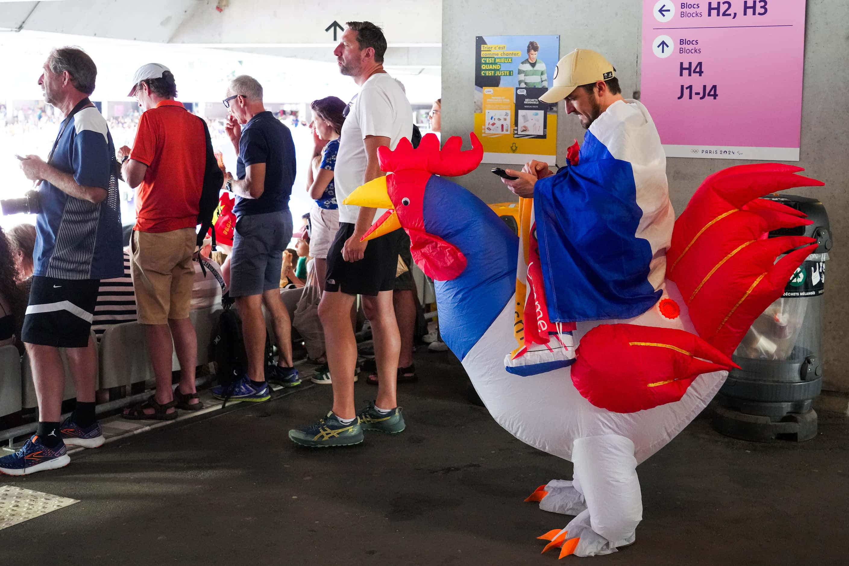 A fan wears French rooster inflatable costume while watching women’s long jump qualification...