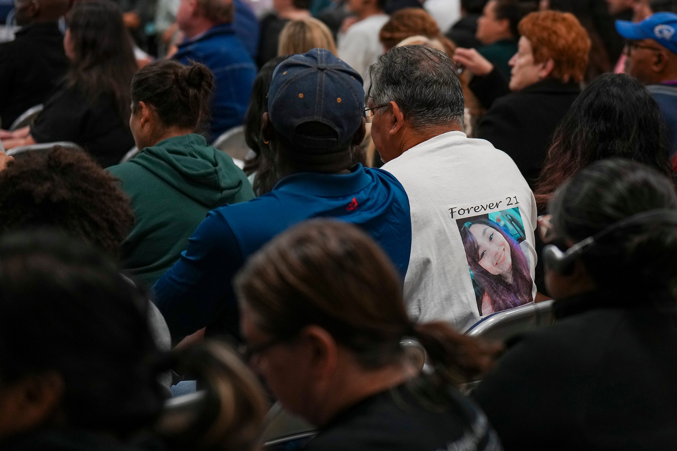 A man wears a t-shirt bearing the photo of Angelina Rogers, a 21-year-old who died of...