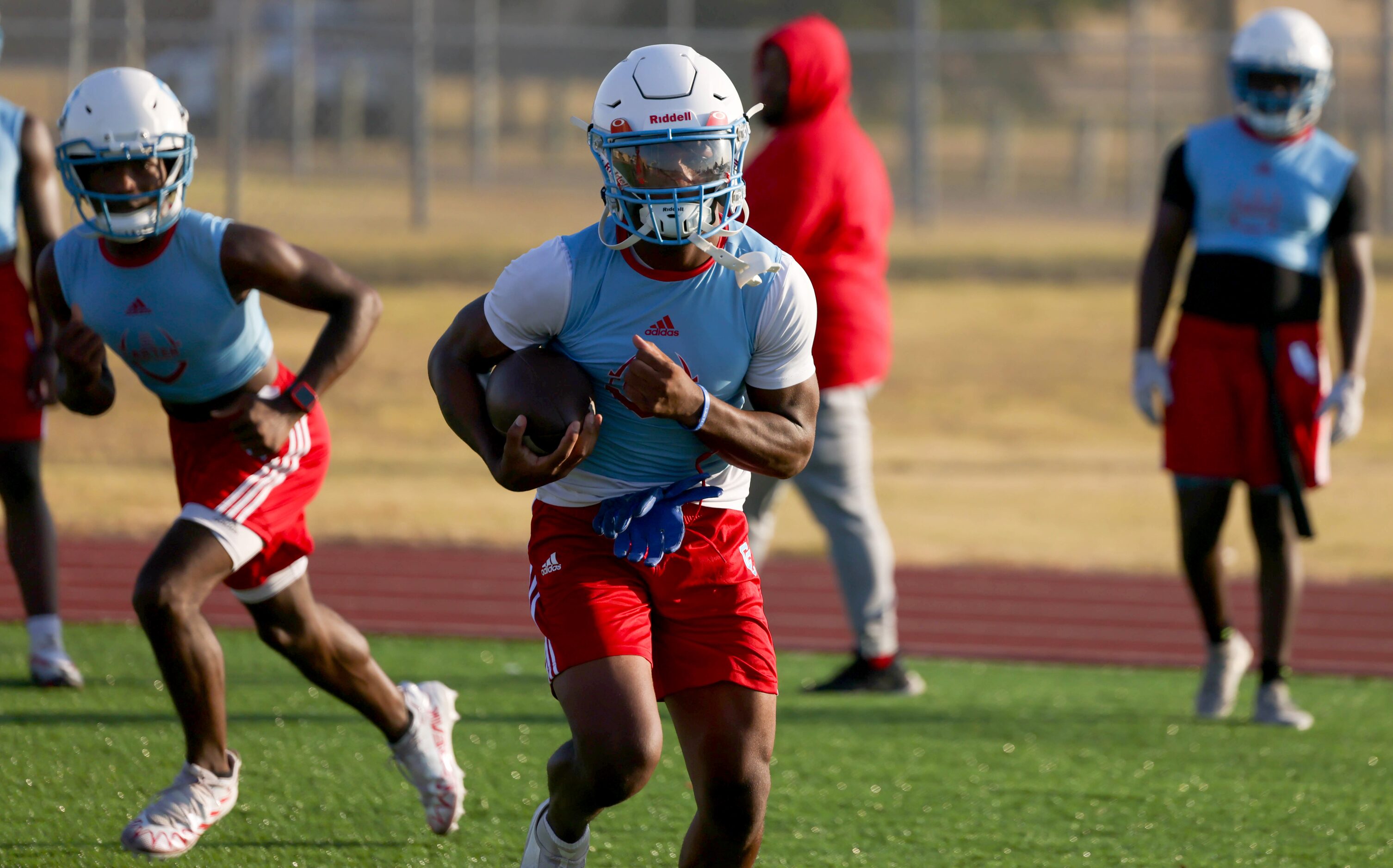 Running back Kaeden Landry (center) carries the ball past offensive linemen as part of a...