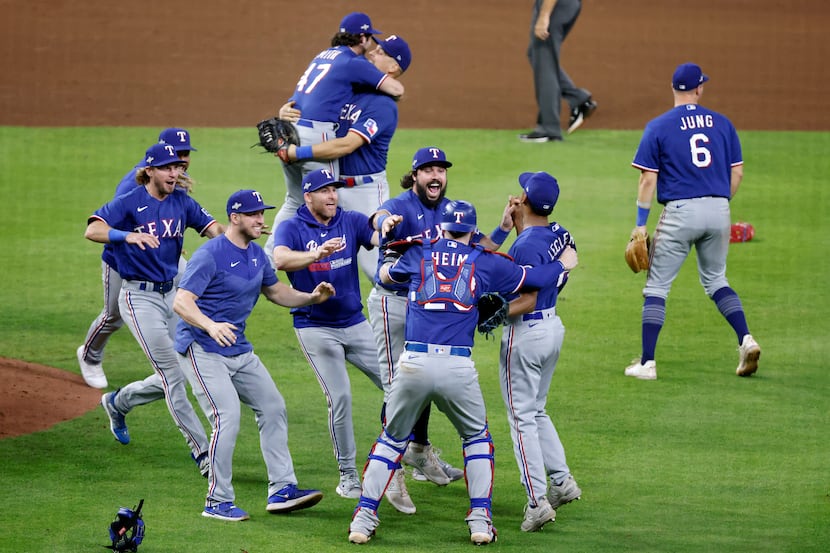 Texas Rangers players celebrate after making the last out of the Houston Astros in Game 7 of...