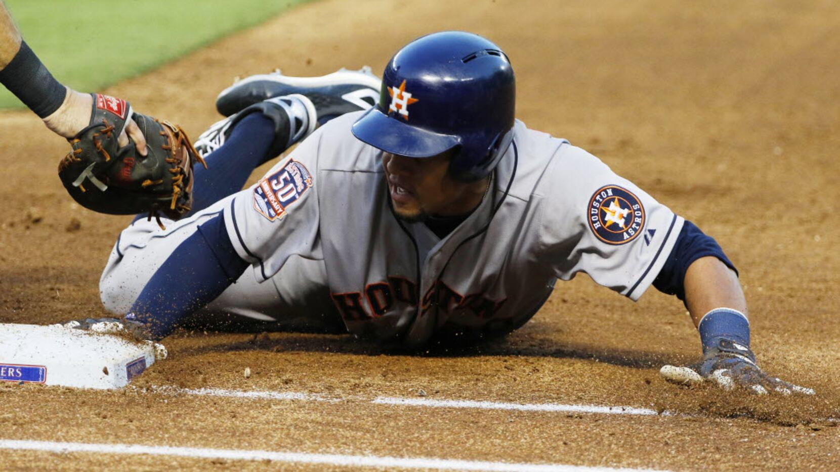 Houston Astros outfielder Carlos Gomez (30) dives back safely past the outstretched glove of...