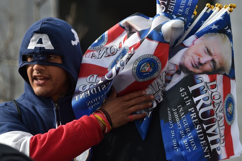 A vendor in a Captain America hoodie sells souvenir flags in a Washington, DC, January 19,...