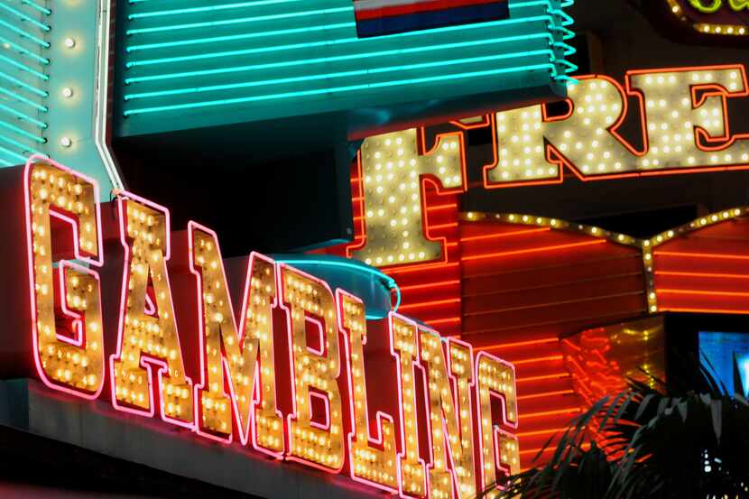 Neon lights up downtown Las Vegas, where thousands of gamblers and college basketball...