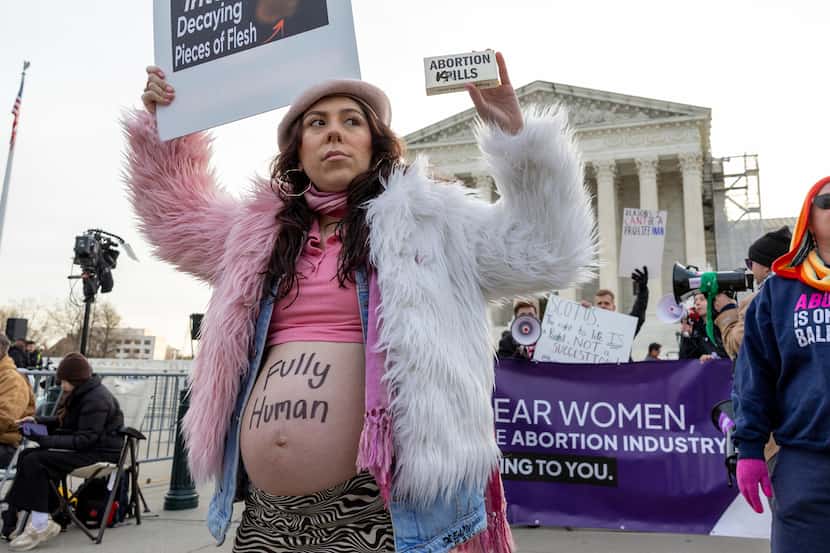 Melanie Salazar of the group Progressive Anti-Abortion Uprising, holds up a mock box of...