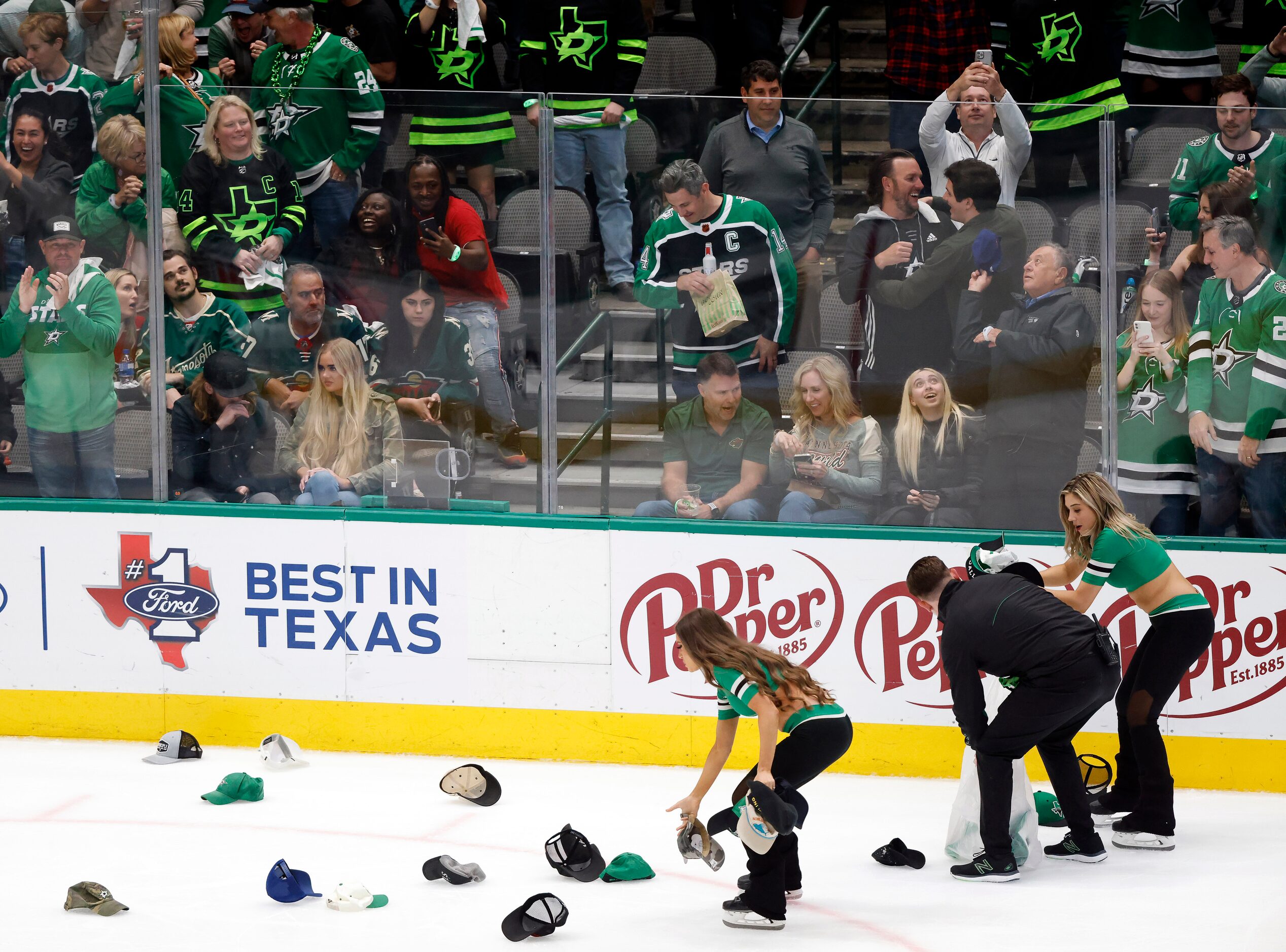 Dallas Stars Ice Girls and staff collects hats thrown on the ice after Roope Hintz’s third...