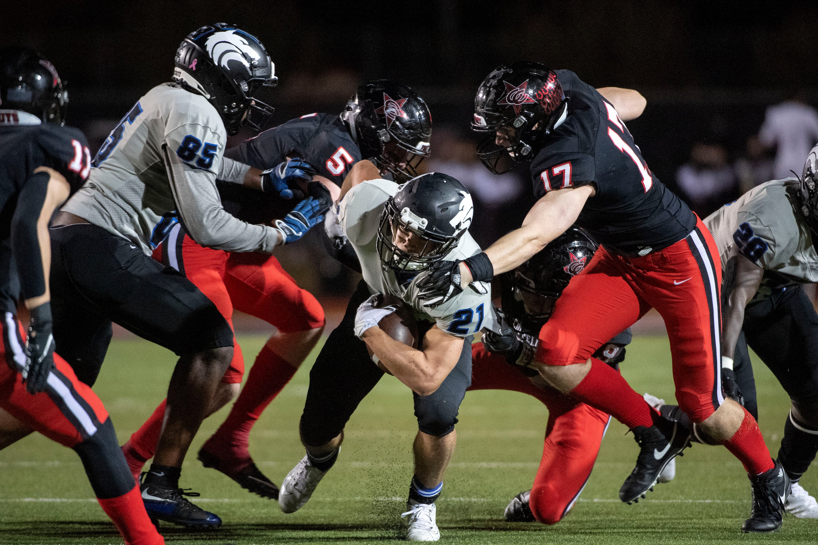 Plano West sophomore running back Dermot White (21) tries to escape the tackle of Coppell...