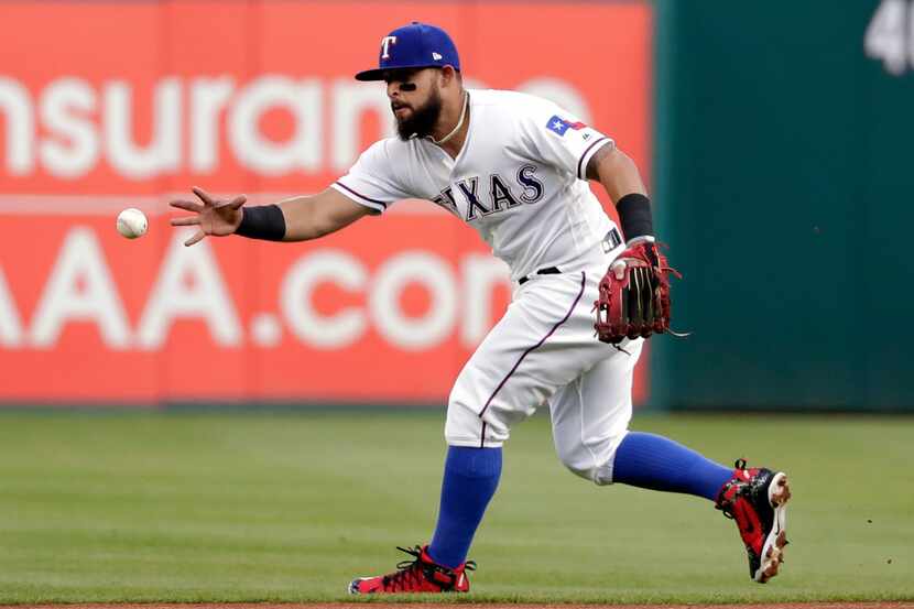 Texas Rangers second baseman Rougned Odor reaches to field a ground ball by Los Angeles...