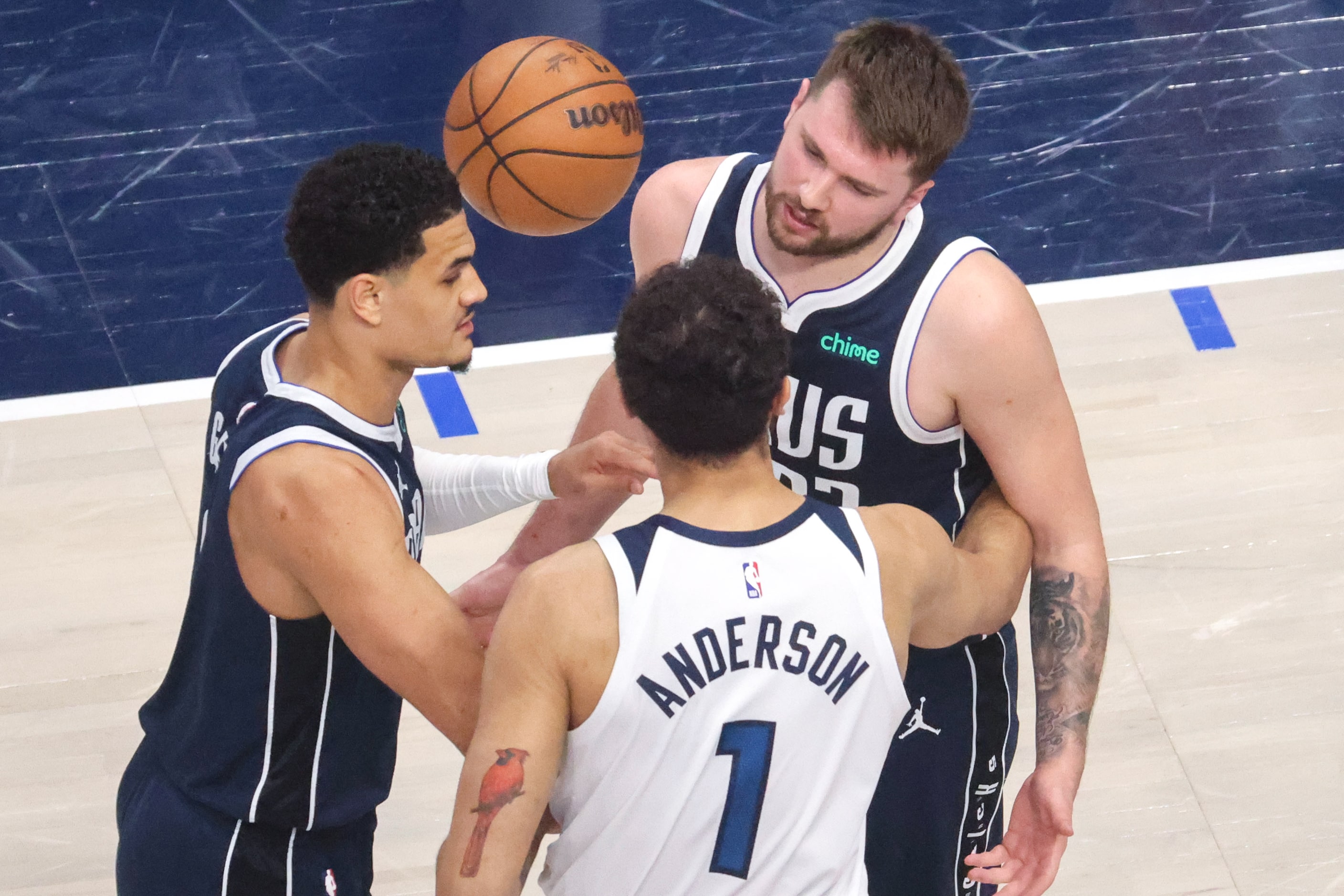 Dallas Mavericks guard Josh Green (left) steps between guard Luka Doncic (back) and...