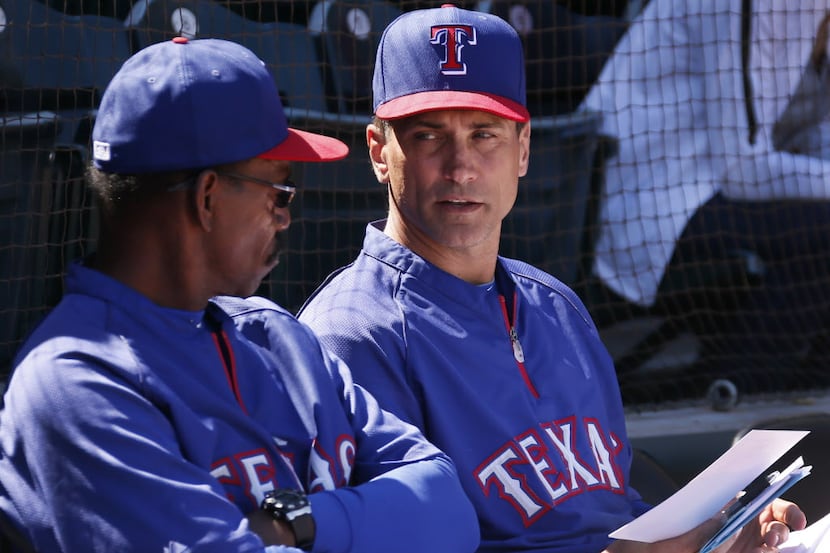 Texas bench coach Tim Bogar, right, talks with manager Ron Washington  before the Cleveland...