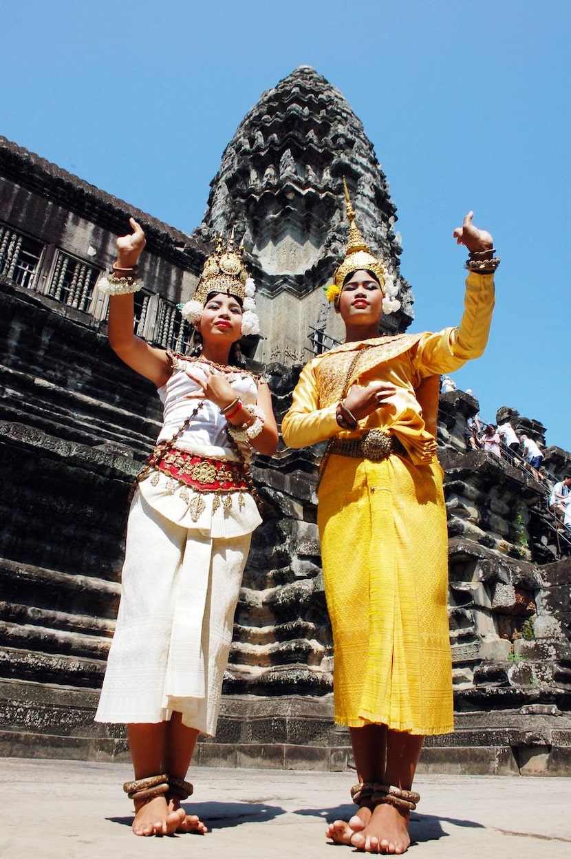 Apsara dancers   strike a pose in front of the tallest tower at Angkor Wat.