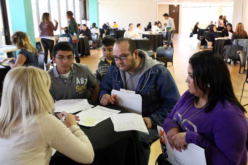 Horacio Estrada, with his children, speaks with an attorney during a clinic sponsored by the...