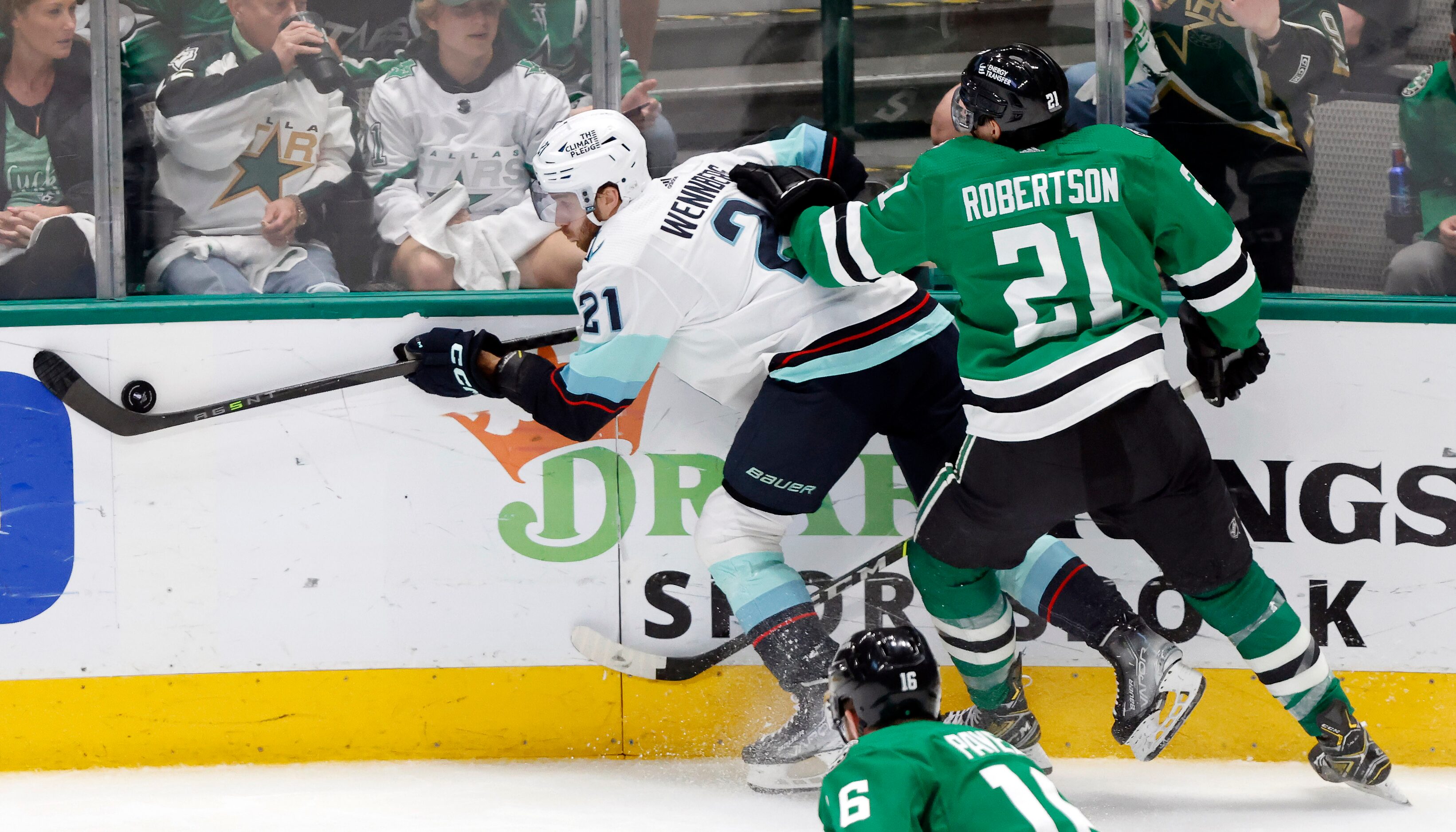 Seattle Kraken center Alex Wennberg (21) controls the puck along the boards as he’s by...