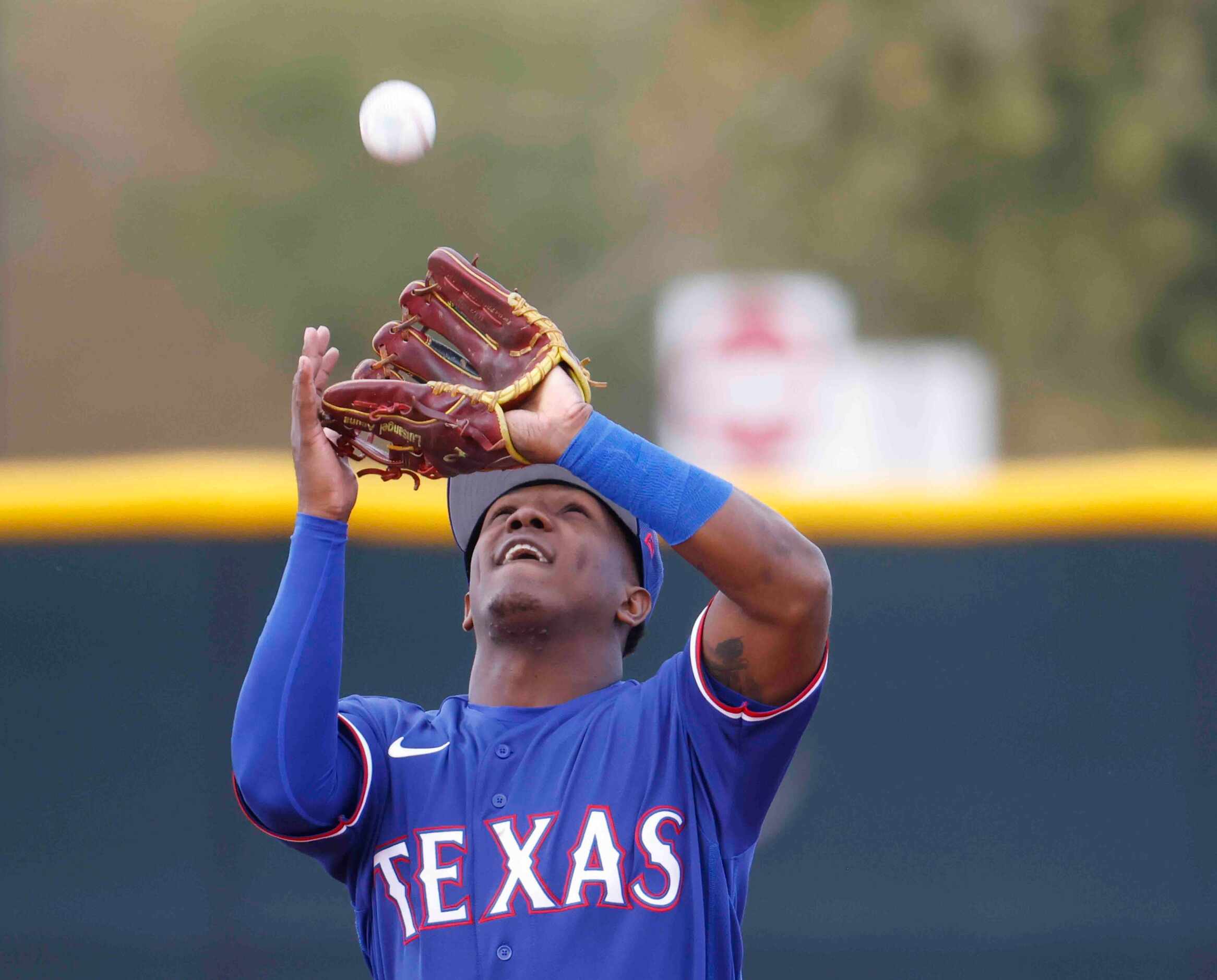 Texas Rangers infielder Luisangel Acuña makes a catch during a spring training workout at...