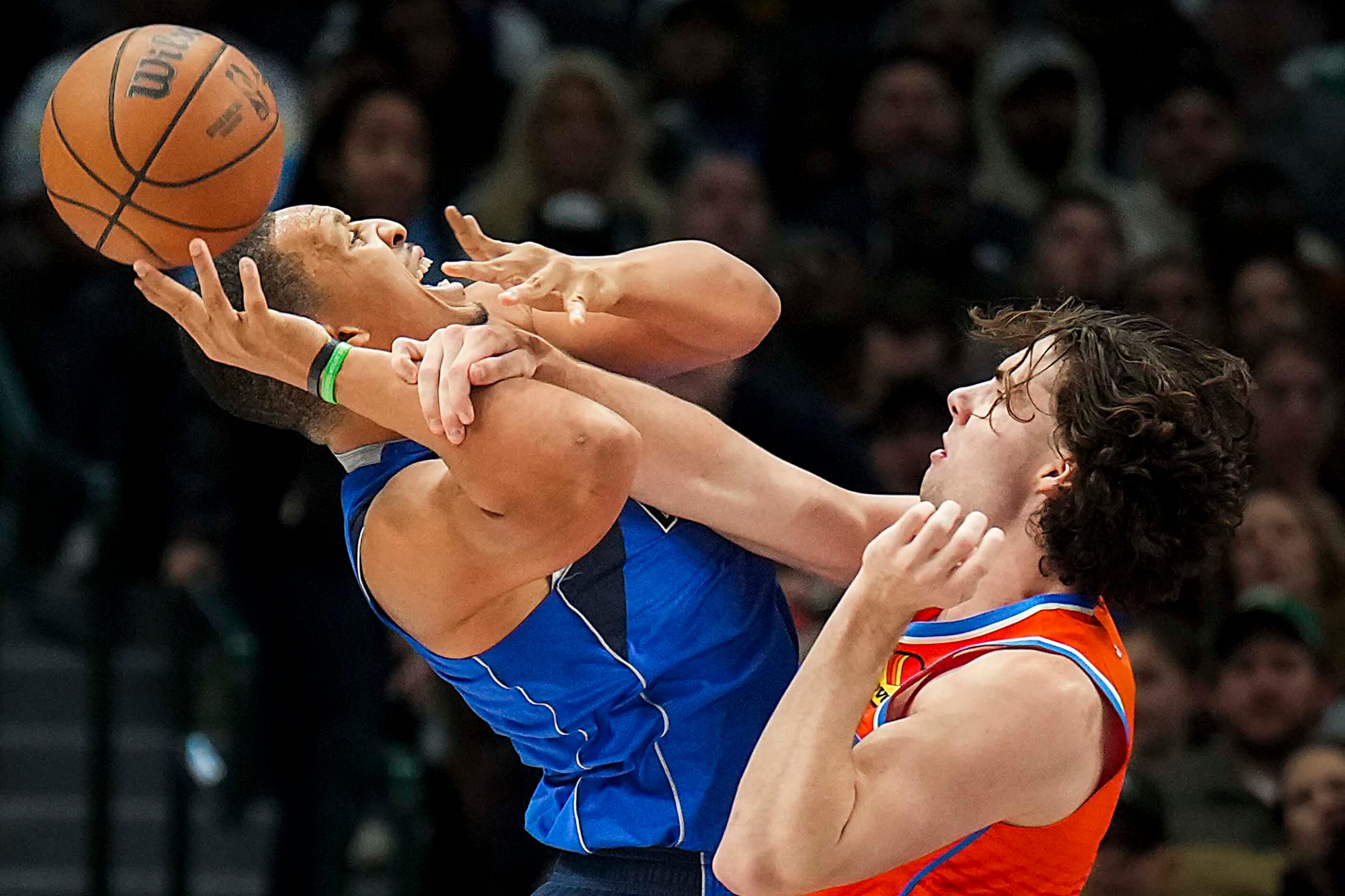 Dallas Mavericks forward Grant Williams is fouled by Oklahoma City Thunder guard Josh Giddey...