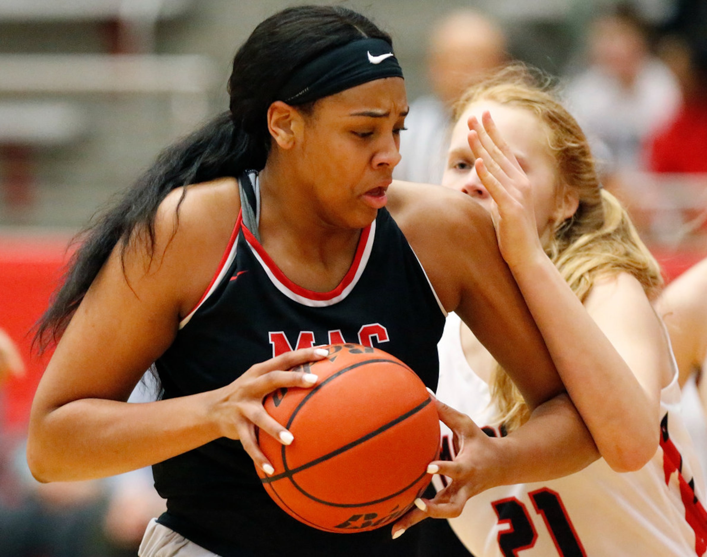 Irving MacArthur High School center Hannah Gusters (21) tries to make a move to the basket...