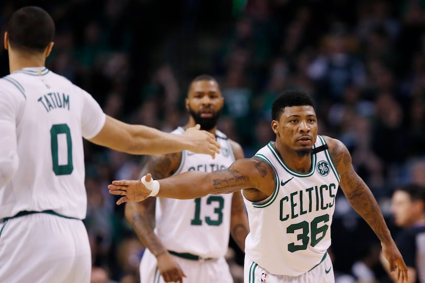 Boston Celtics guard Marcus Smart (36) reaches to slap hands with forward Jayson Tatum (0)...