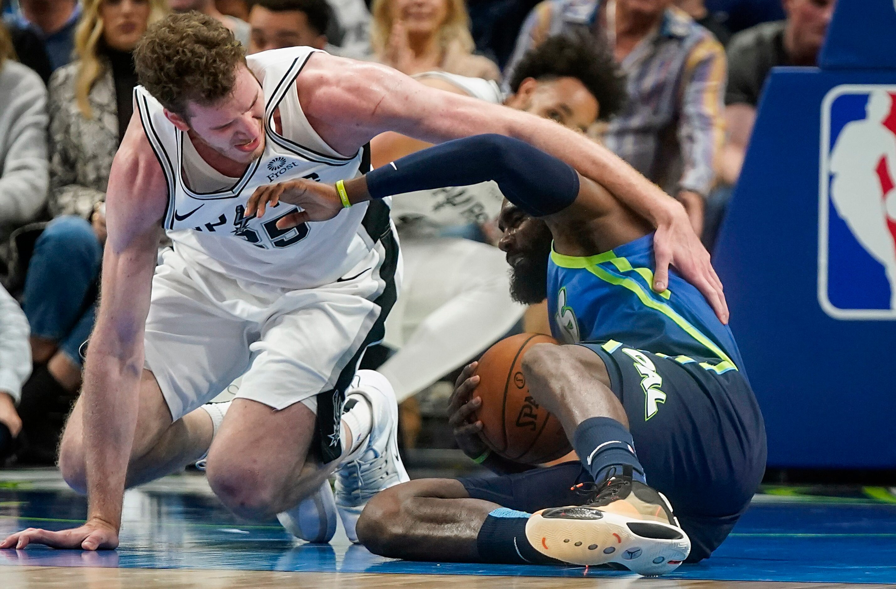 Dallas Mavericks guard Tim Hardaway Jr. (11) fight for a loose ball against San Antonio...