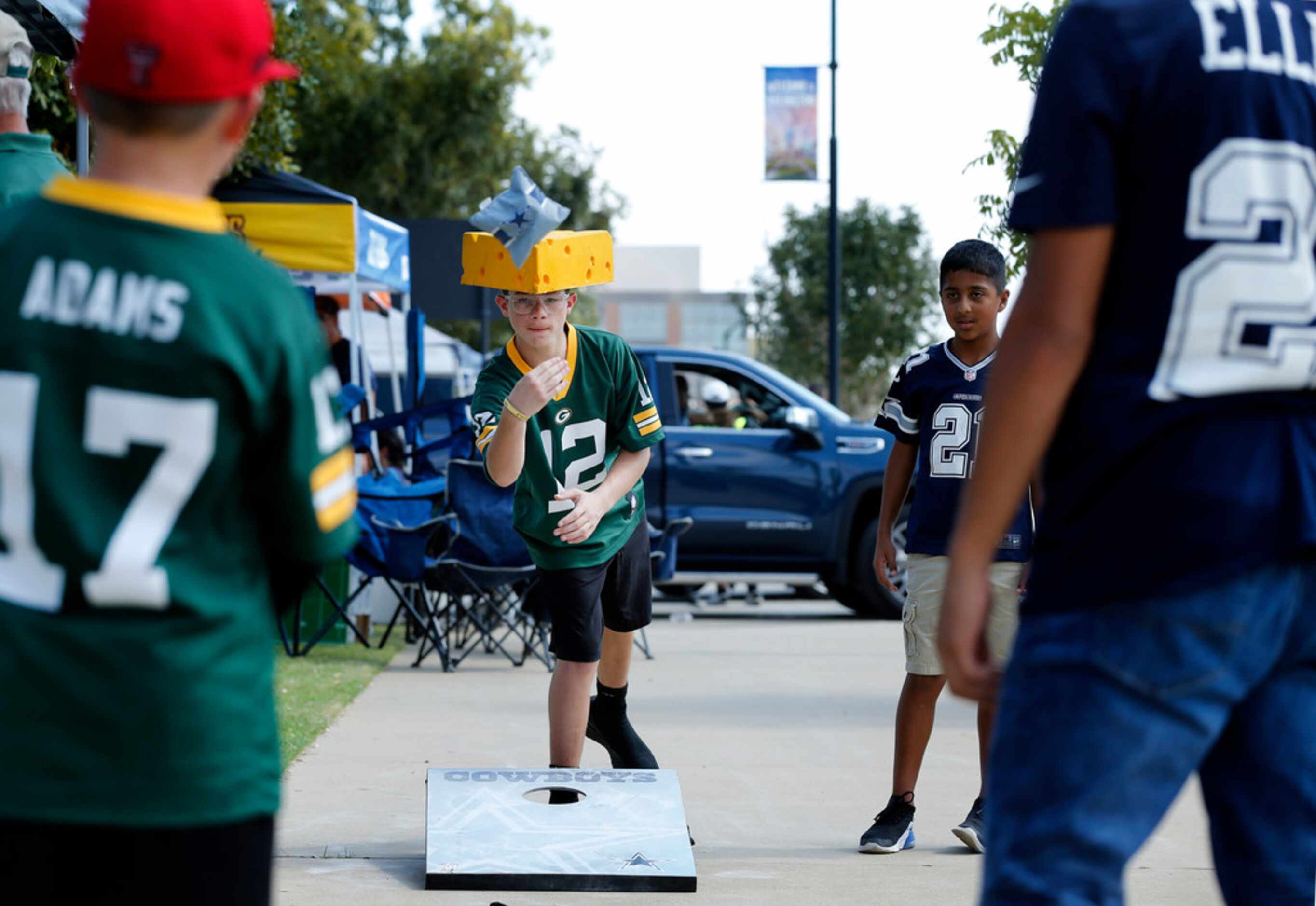 Green Bay Packers fan Daxston Swimmer of Plains, TX tosses corn bags during a game of corn...