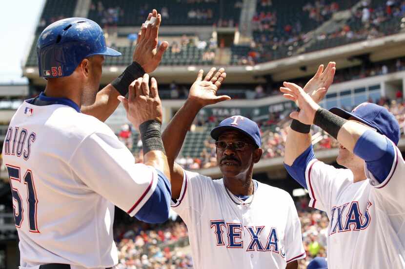 Texas Rangers right fielder Alex Rios (51) celebrates with manager Ron Washington (38) after...