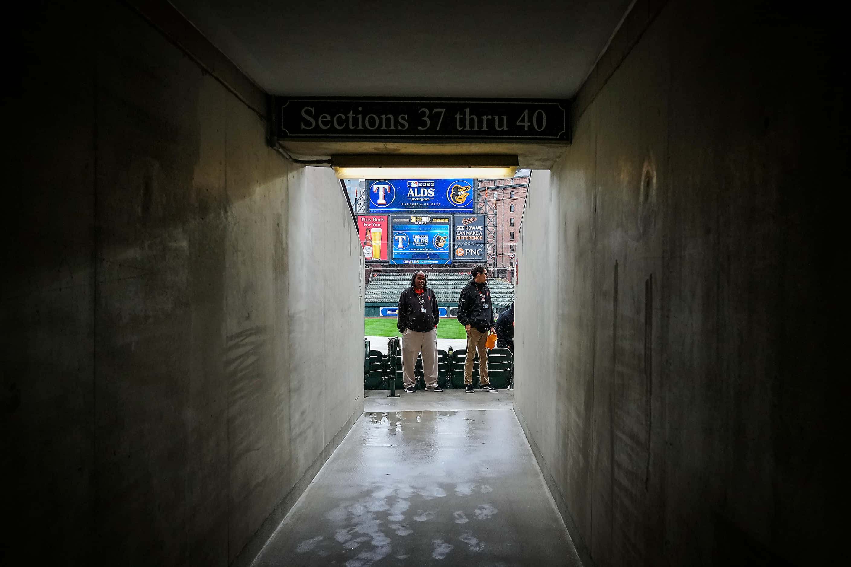 Ushers stand in a light rain prior to Game 1 of an American League Divisional Series between...