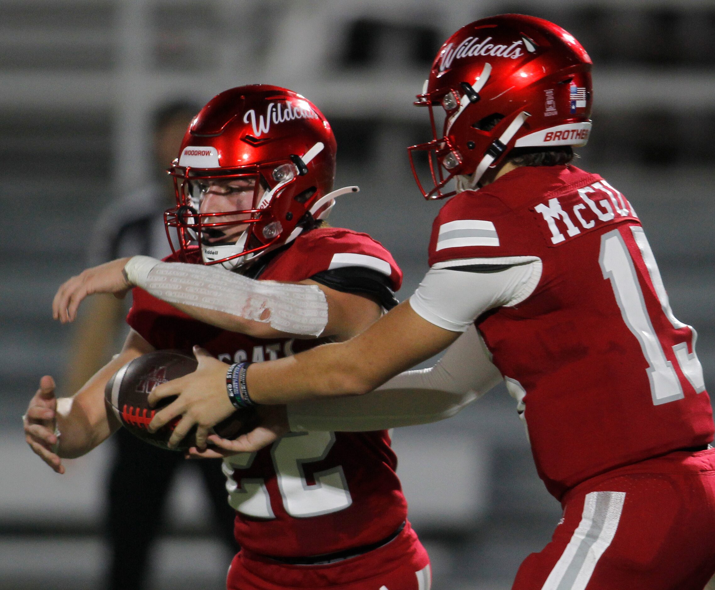 Dallas Woodrow Wilson quarterback Cam McGuire (15), right, hands the ball off to running...