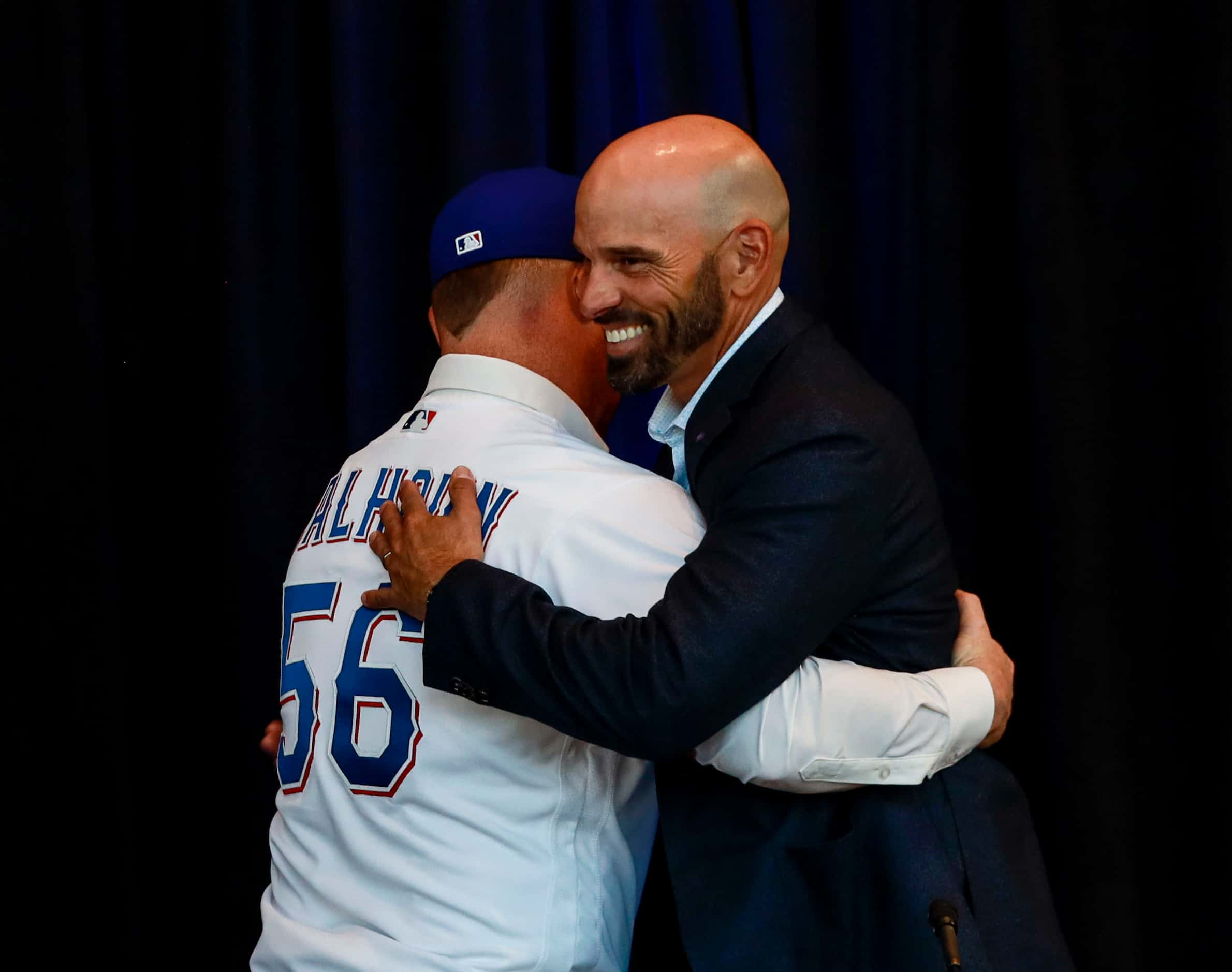 Kole Calhoun hugs Texas Ranger's manager, Chris Woodward, at a news conference at Globe Life...