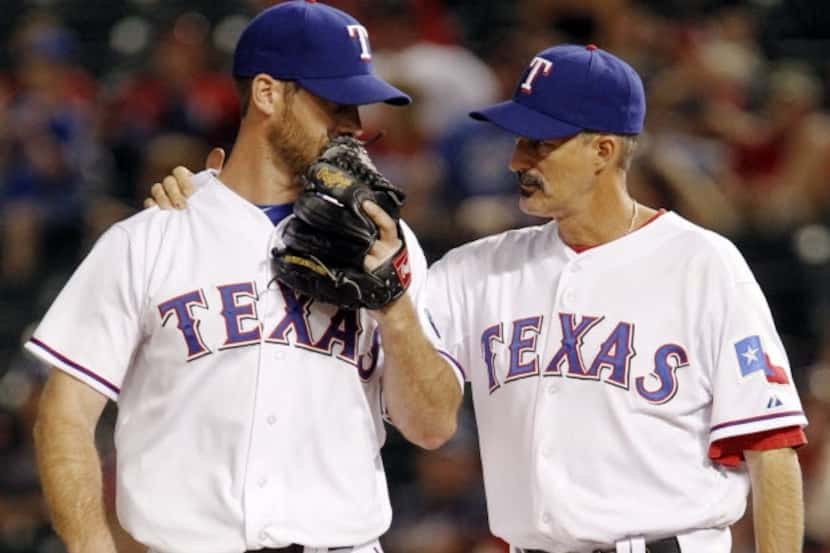 Former Texas Rangers starting pitcher Dave Bush (left) listens to Texas Rangers pitching...