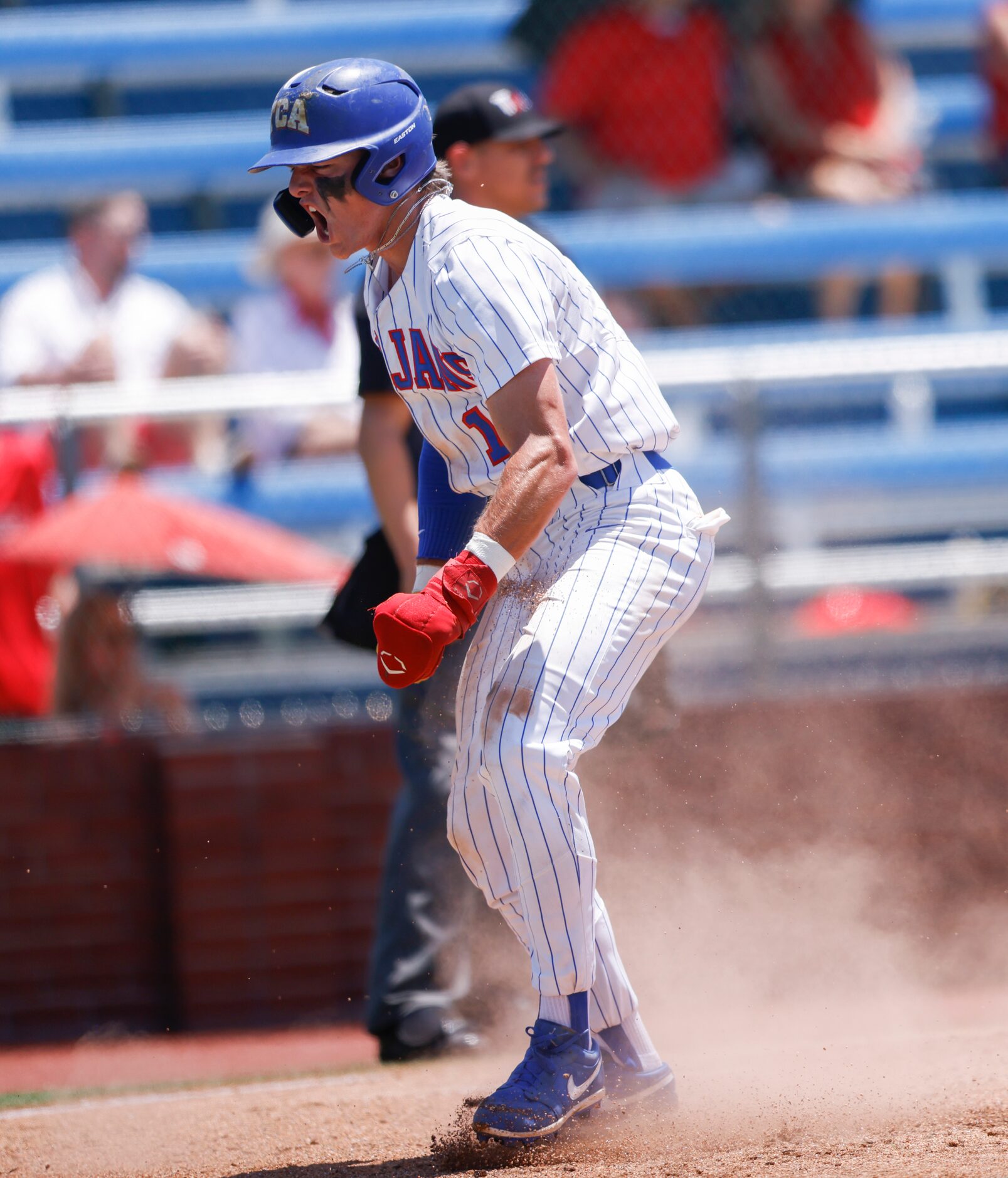 Trinity Christian’s Samuel Jenkins (10) celebrates after sliding into home in the fourth...