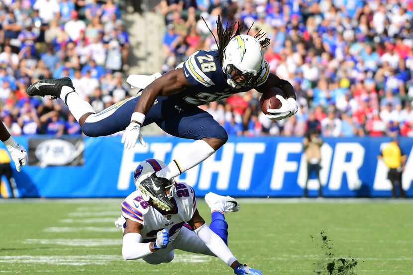 CARSON, CA - NOVEMBER 19:  Melvin Gordon #28 of the Los Angeles Chargers leaps over E.J....