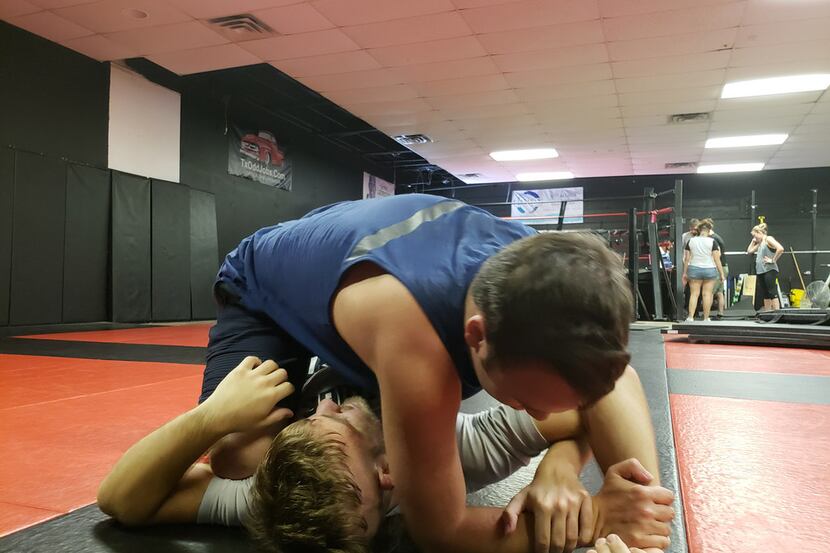 In this file image, Dylan Miller (top) practices a jiu-jitsu drill on Levi Mowles at Fitness...