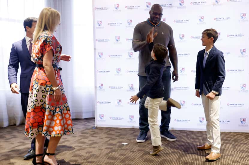 Wyatt Chilian, 9, reaches to high-five 7 foot-1 inch pro basketball Hall of Famer Shaquille...