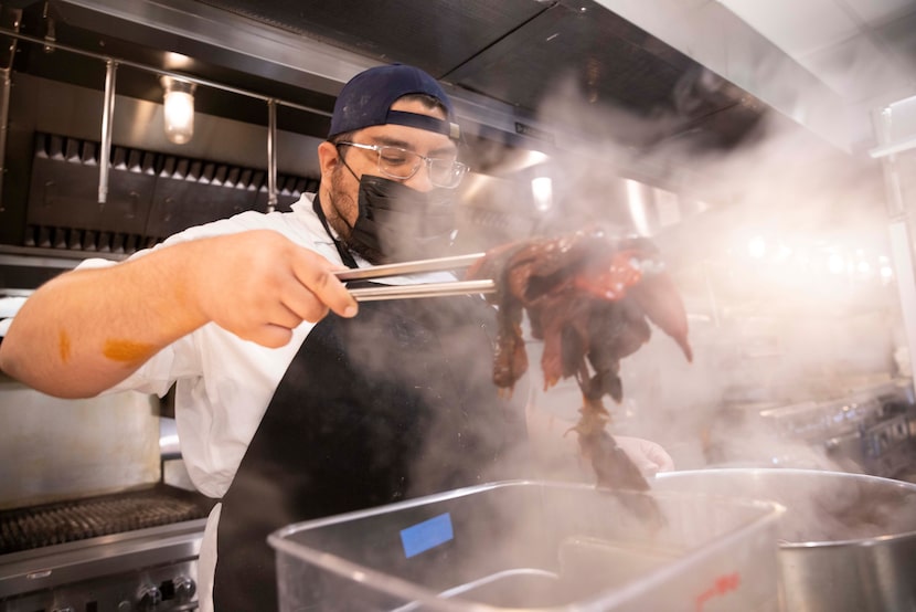 Prep cook Emanuel Medina prepares boiled chilis for an adobo at Anise.