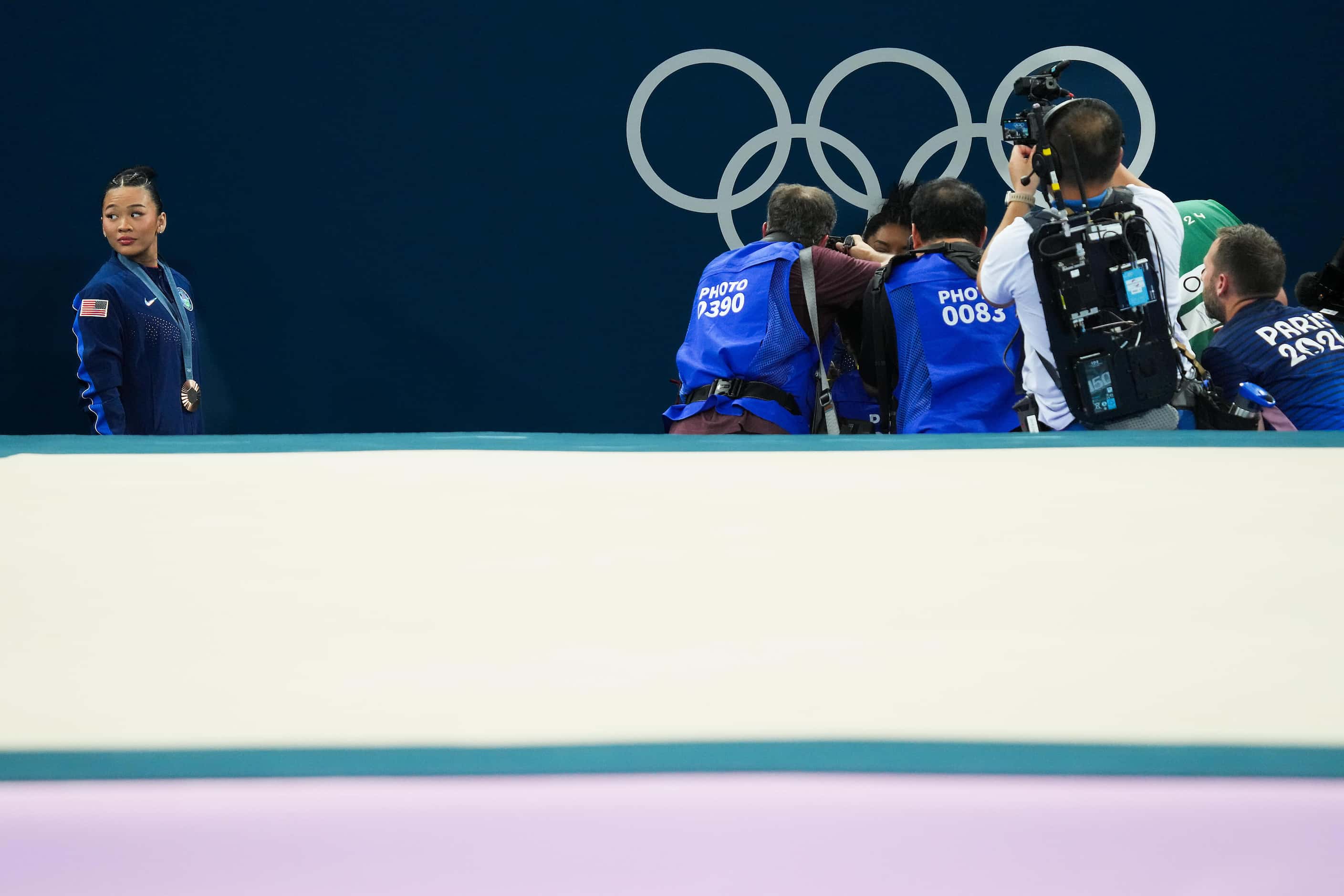 Bronze medalist Suni Lee of the United States steps to the side as gold medalist Simone...