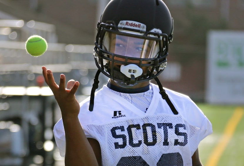 Running back Davenn Robinson tries to catch a tennis ball during drills at football practice...