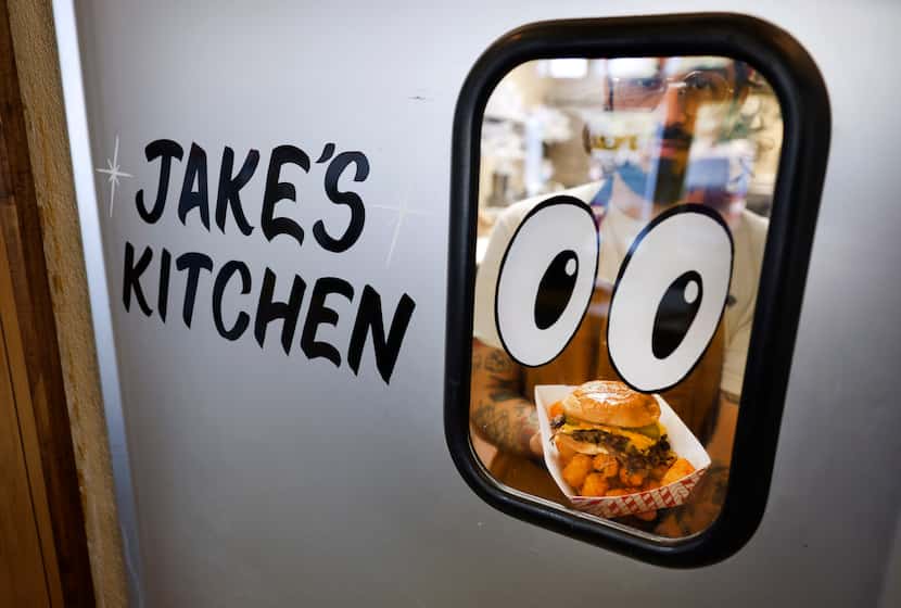 Chef Jake Saenz walks through the kitchen door with an OG Smashburger.