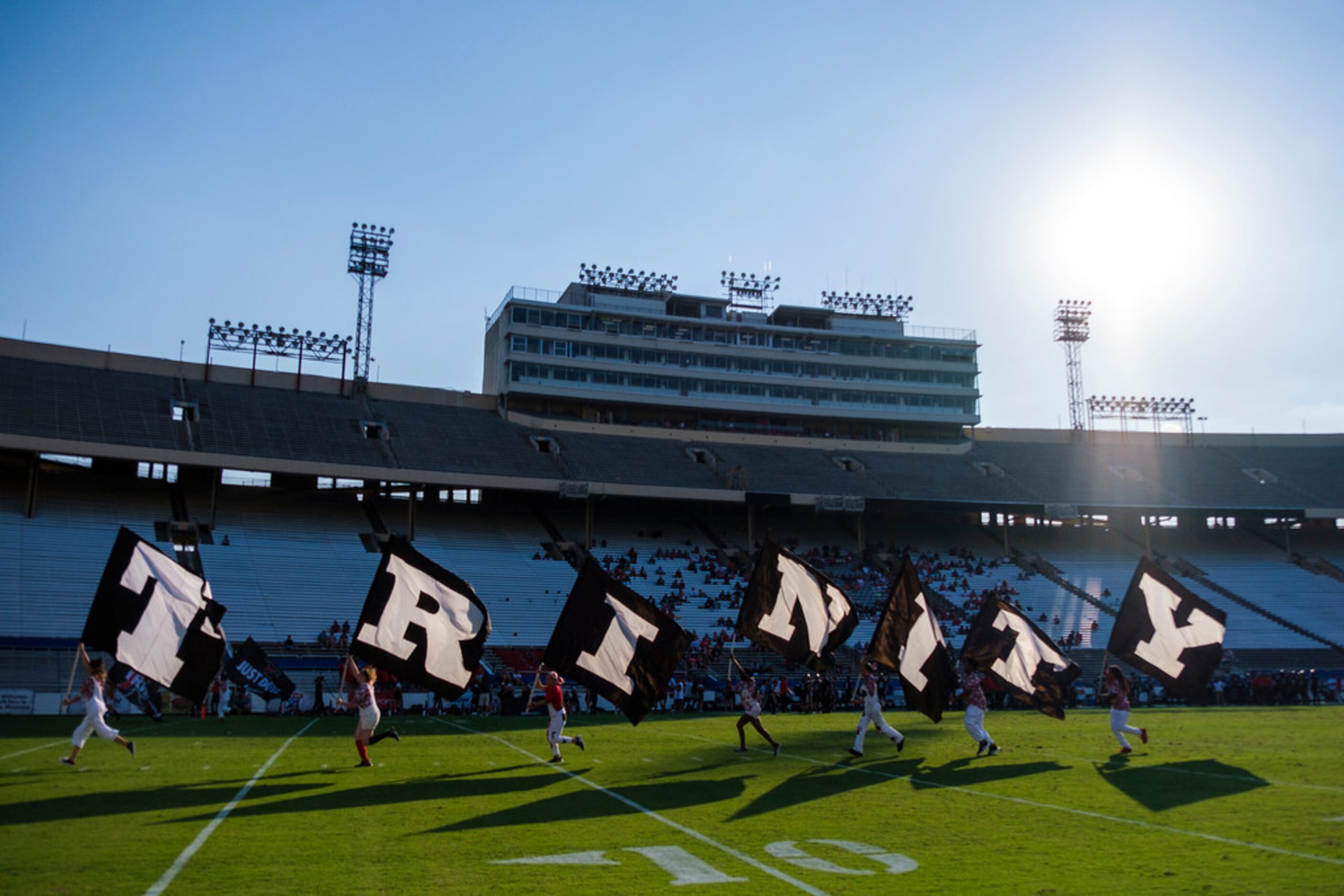 Euless Trinity flag runners race across the field after a touchdown during the first half of...