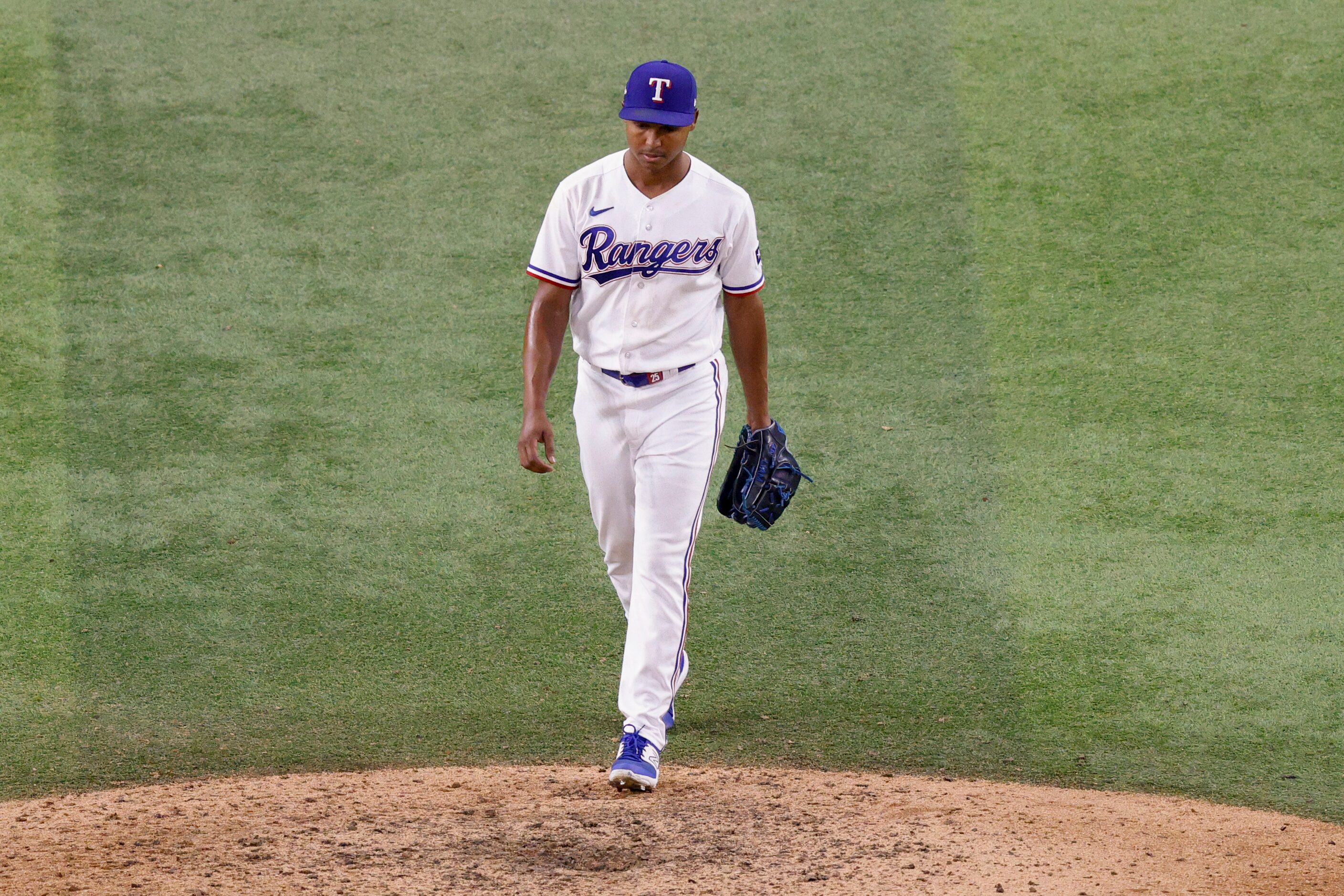 Texas Rangers relief pitcher Jose Leclerc walks back to the mound after giving up the...