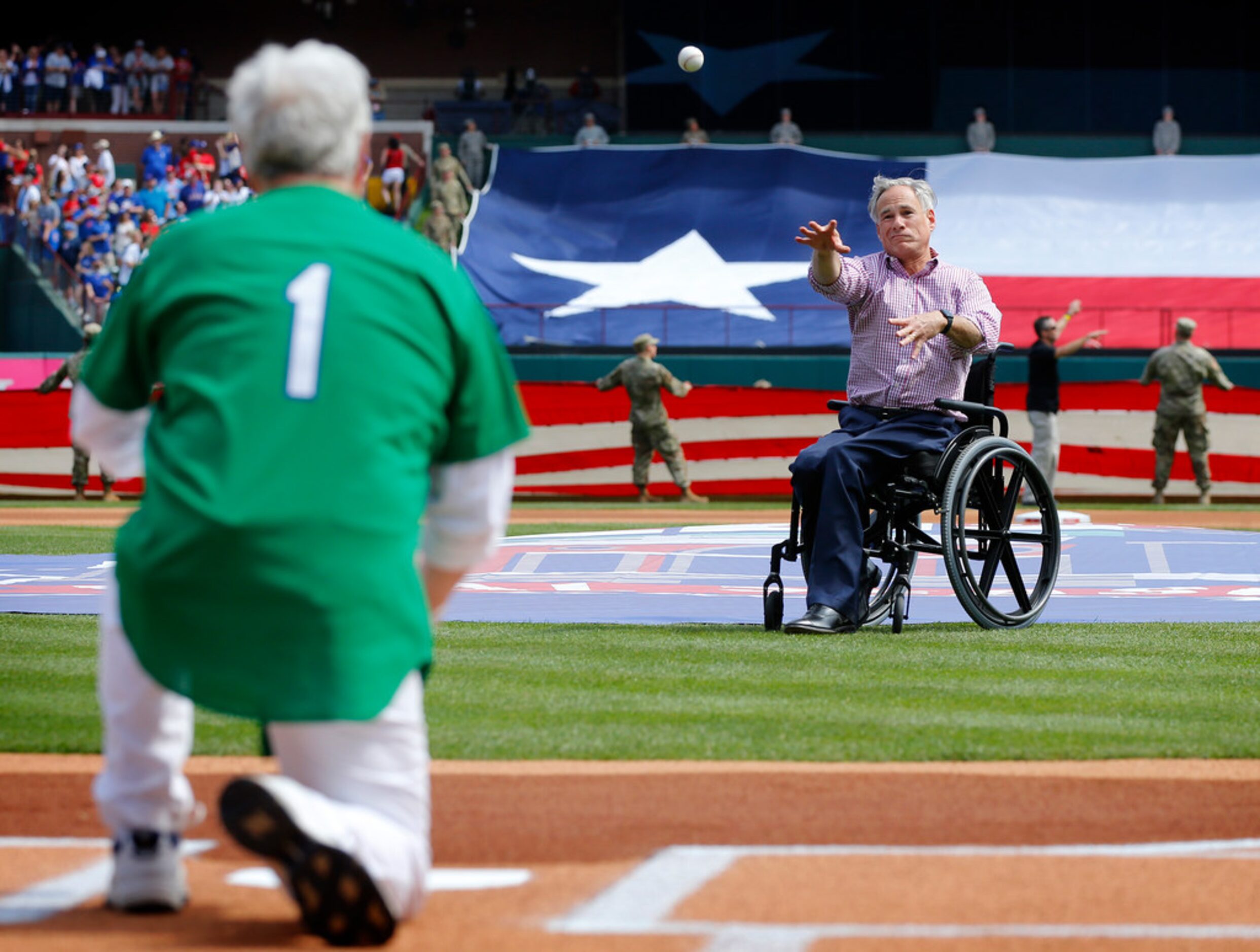 Texas governor Greg Abbott throws the ceremonial first pitch to former Arlington mayor...