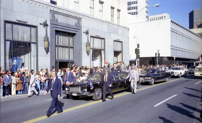 President Gerald Ford waves to the crowd as he passes the Lone Star Gas Co Building on...